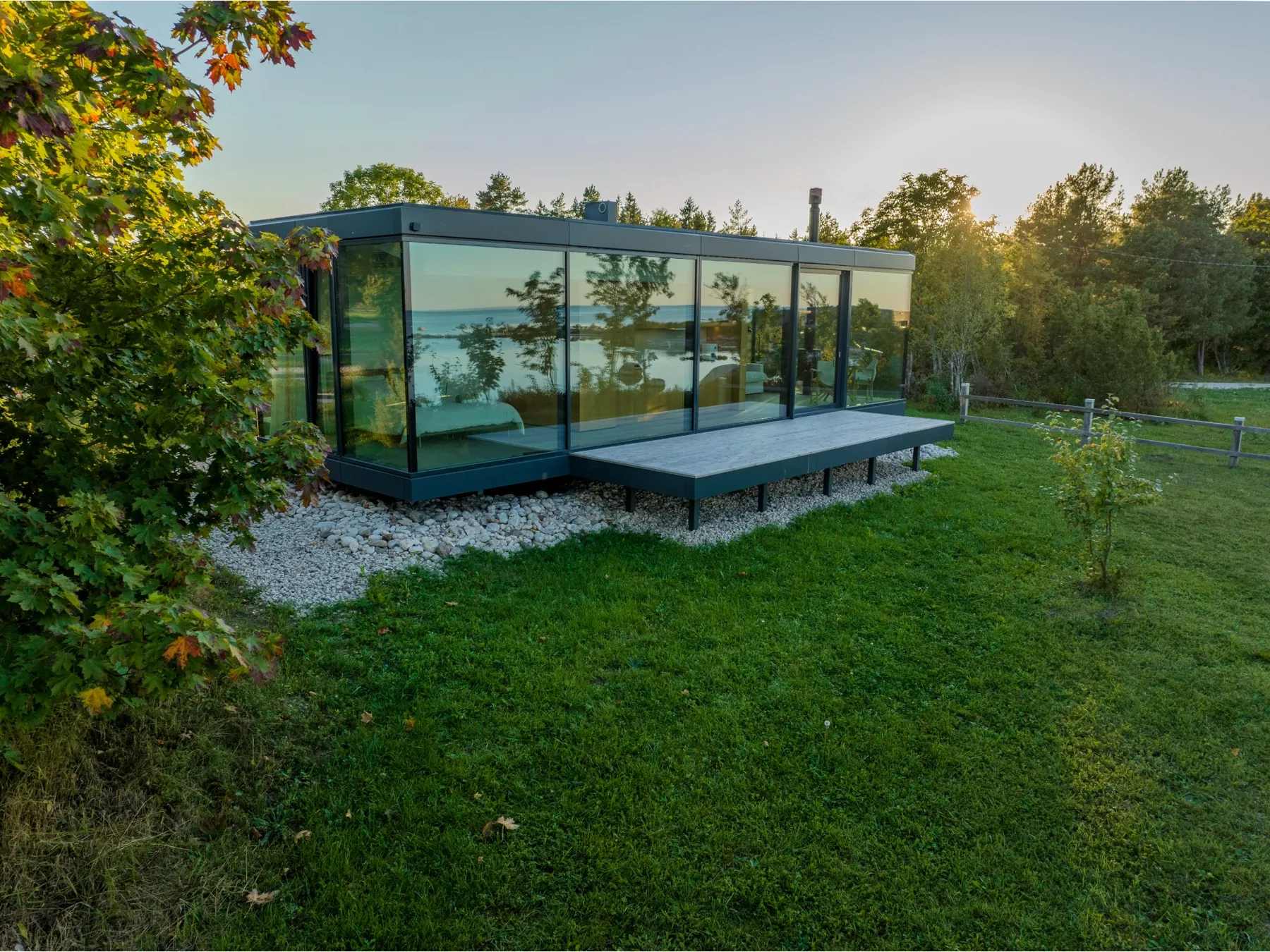 Signature seen from above among trees, sky and treeline reflected in the glass