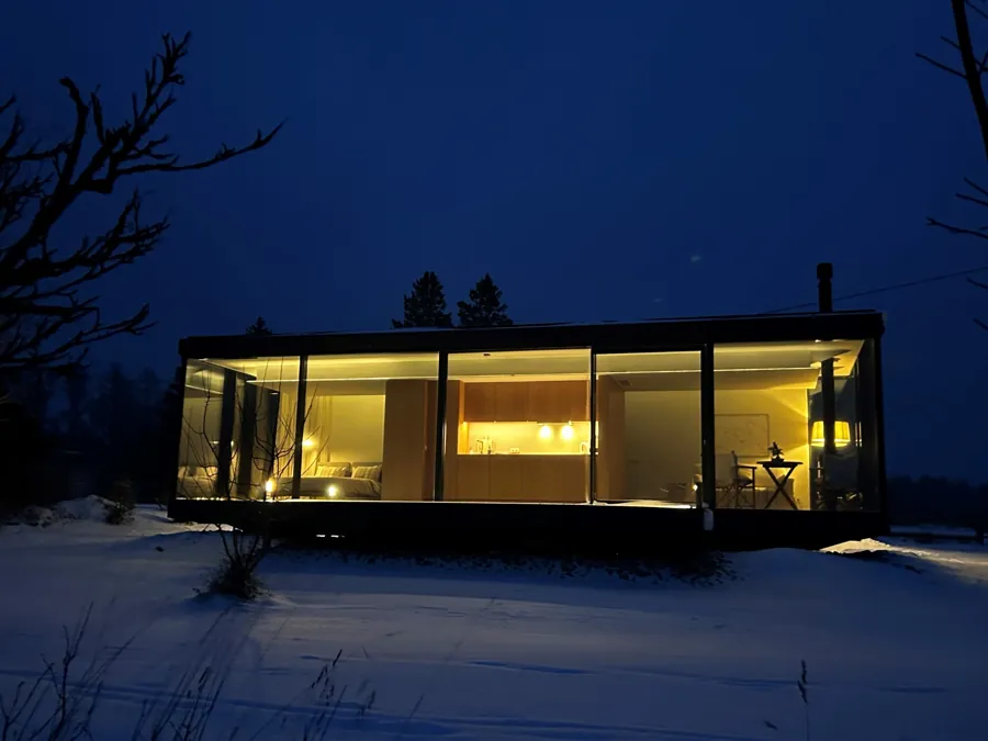 Signature with dark timber cladding in snow at blue hour