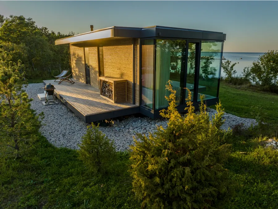 Signature with timber cladding on a gravel bed, the sea behind it