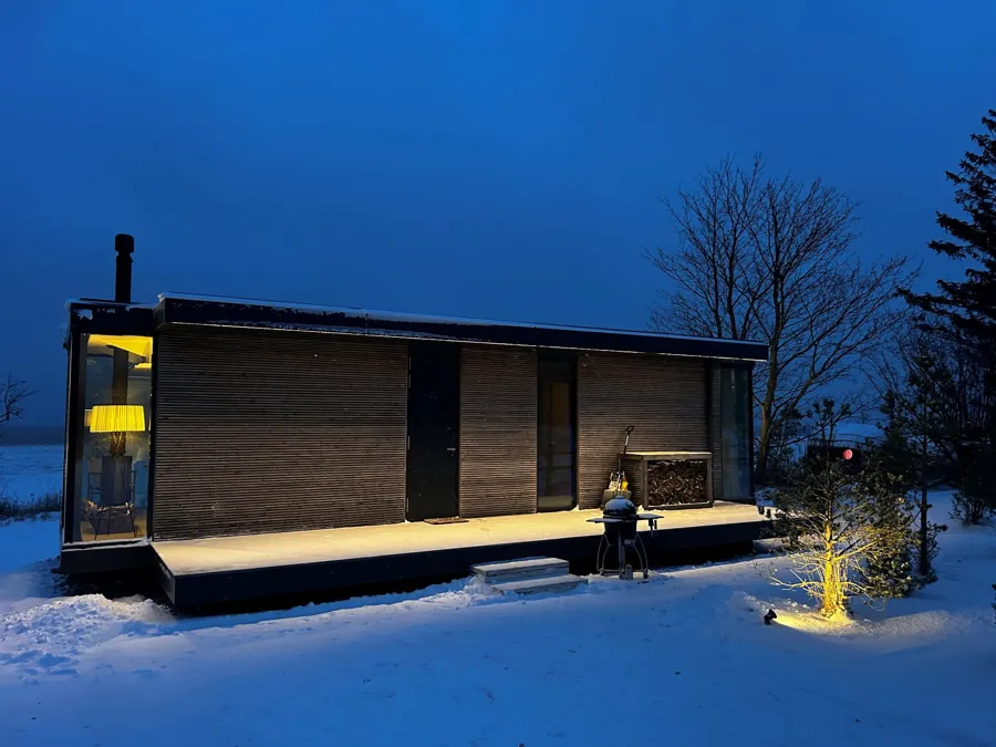 Signature at night in snow with a small tree lit beside it