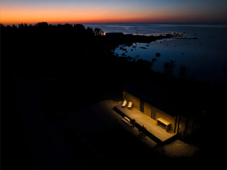 A lit Signature on a dark coastline, the last orange light over the sea