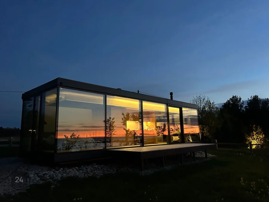 Signature glass facade glowing warmly against a vivid evening sky