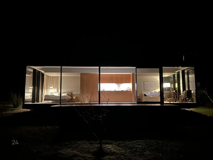 Signature illuminated at night with its full glass facade visible