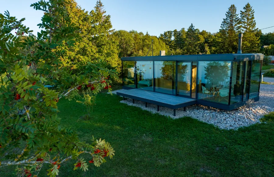 Signature glass house surrounded by summer greenery
