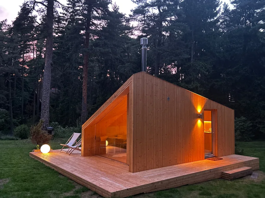 Real Etnika Zen cabin glowing warmly beneath the pines at dusk