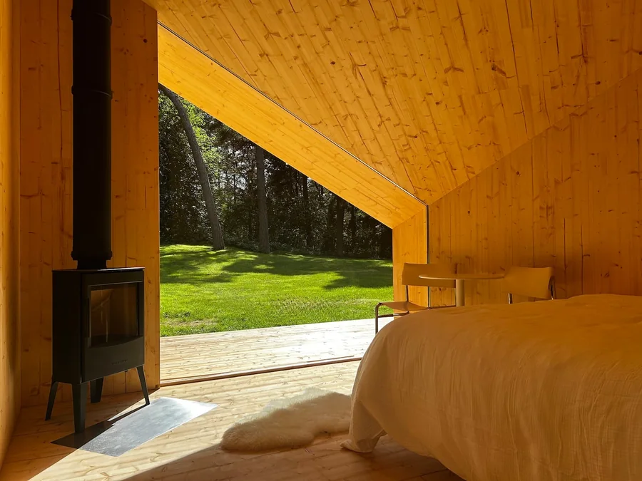 Real Zen interior with sleeping area, wood stove and an open view to the forest