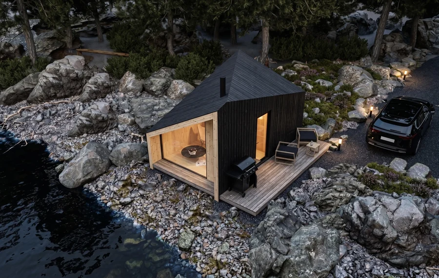 Zen Sauna concept in dark timber on a rocky shoreline at dusk